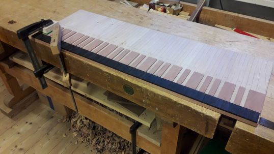 Die hinteren Beläge aus Birnbaum werden ebenfalls auf der Platte aufgeleimt