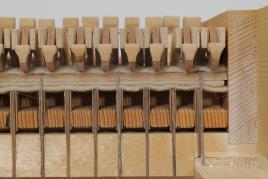 Die Kanzellen der Tastenhinterführung mit aufgebundener Abdeckleiste, auf der die Hammerstiele aufliegen.